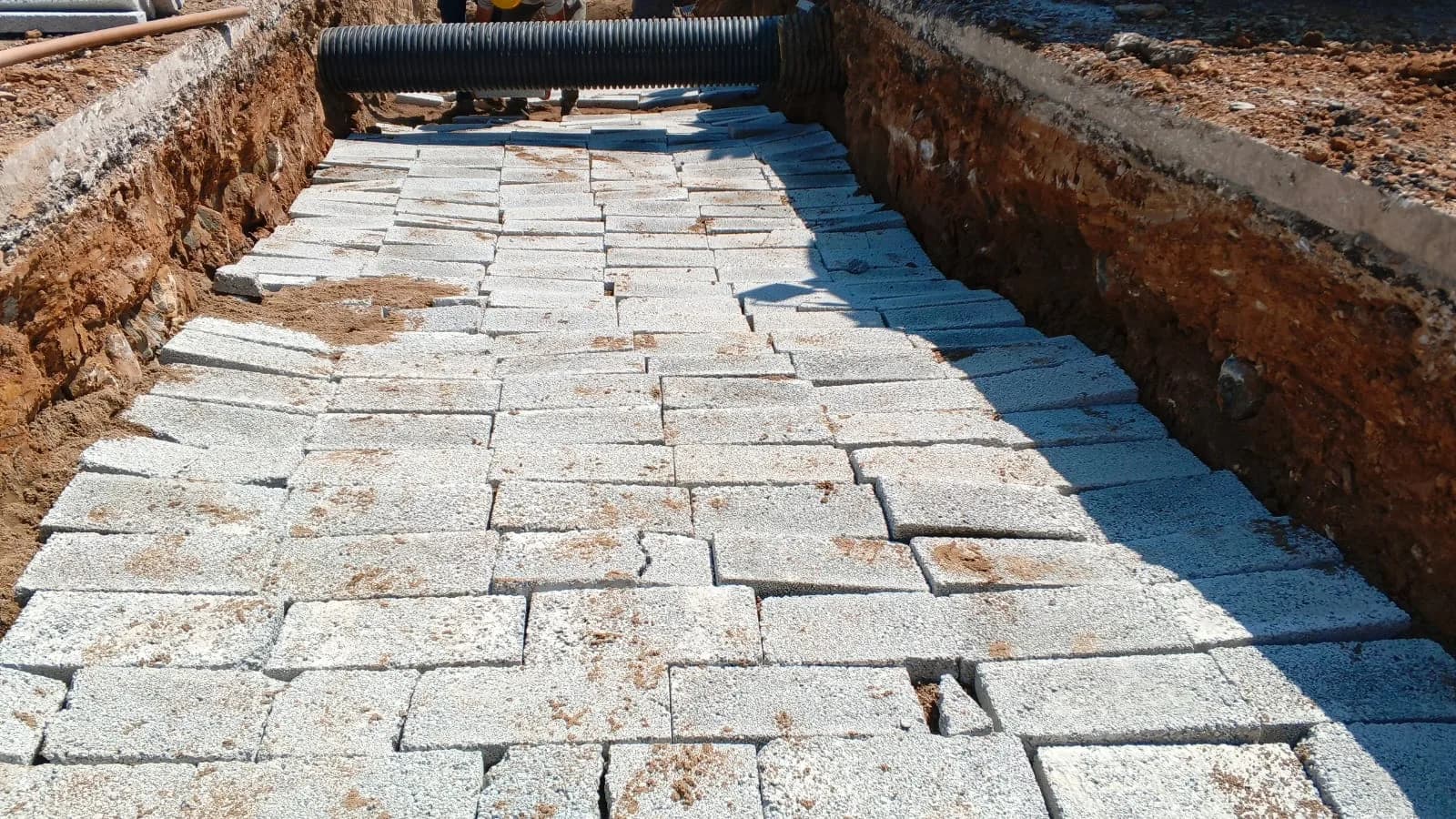 Kanalın üstü beton plakalarla kapatılmış, yanında koruge boru geçişi