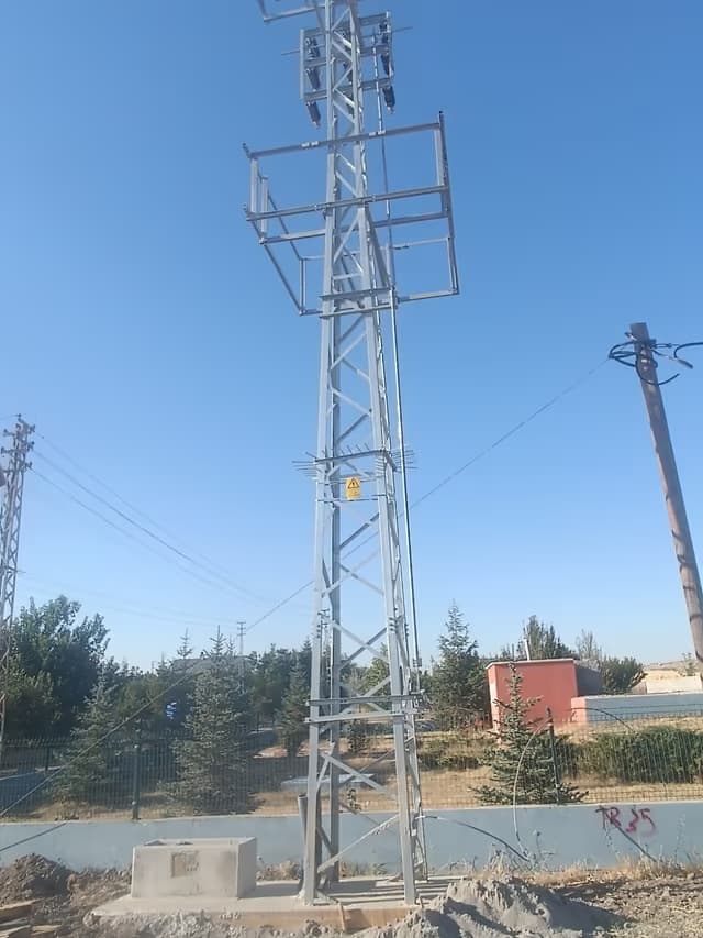 Kırsal güzergâhta dikilmiş kafes direk ve enerji nakil hattı