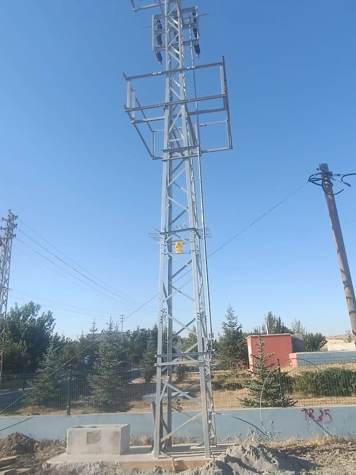 Kırsal güzergâhta dikilmiş kafes direk ve enerji nakil hattı