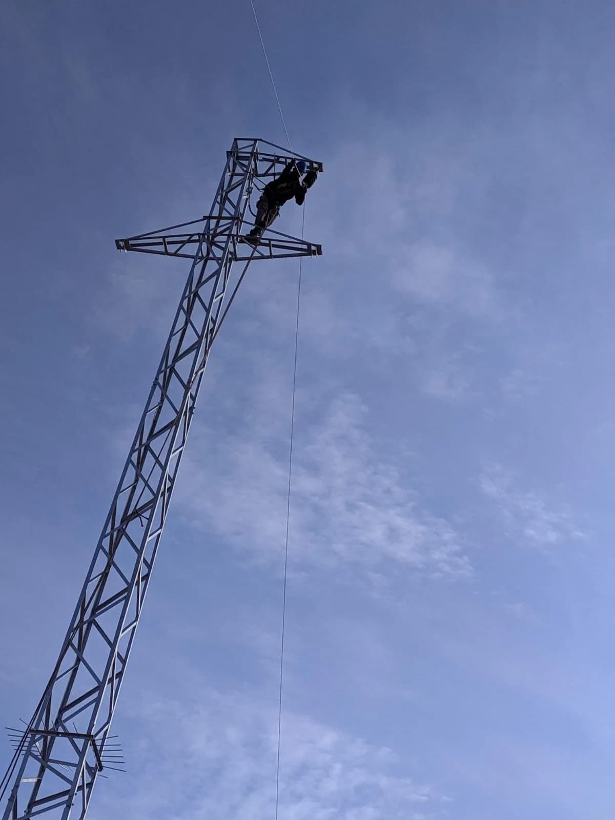 Direğin tepesinde emniyet kemeriyle çalışan hat işçisi